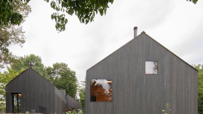 Two black timber barn-style buildings by Worrell Yeung