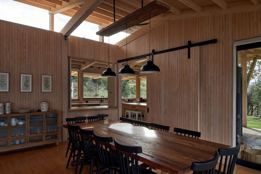 A dining room in a timber structure with a pitched roof and high-level windows