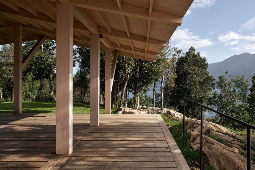 Timber structure of a house extending over wood-decked terrace