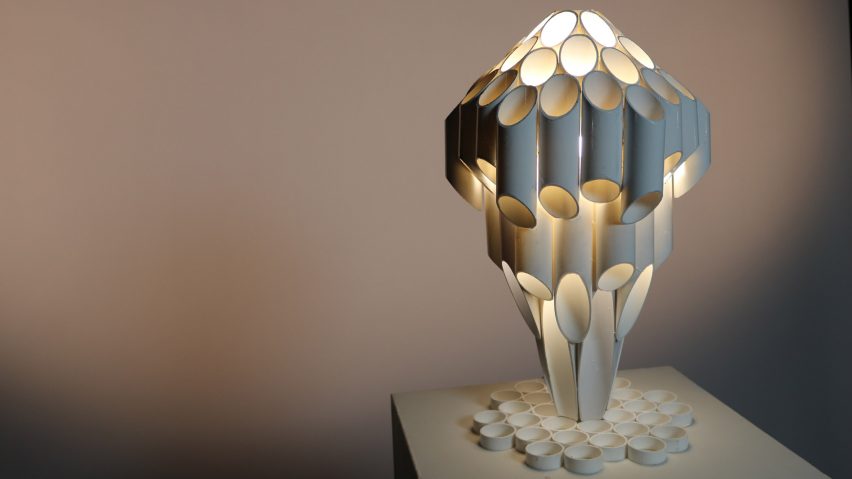 Lamp made up of tubes in front of grey backdrop