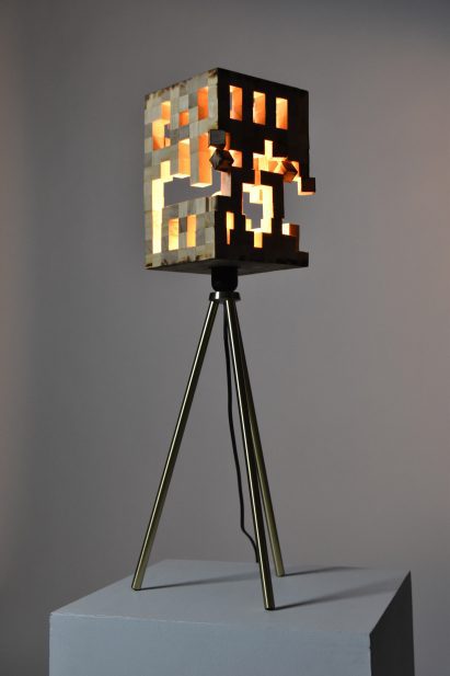 Lamp on tripod stand in front of grey backdrop