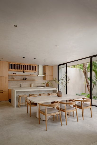 Open-plan kitchen with neutrally hued wooden furniture