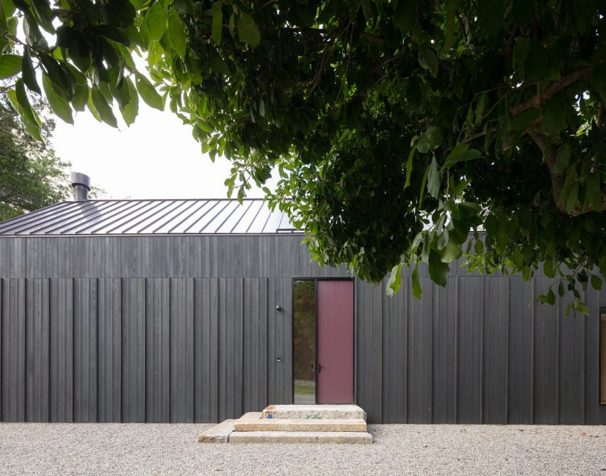 Entrance to a black timber-clad barn-style home