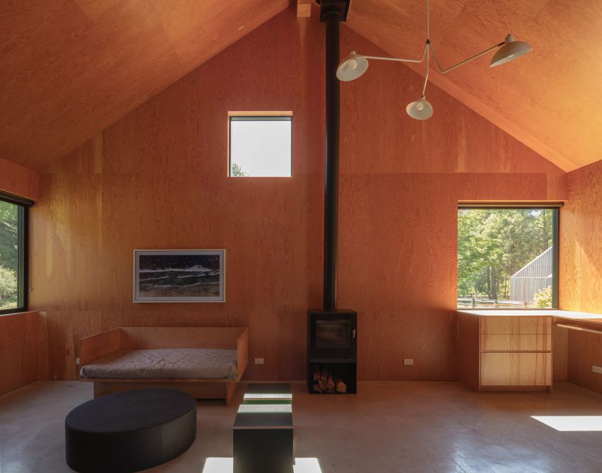 Interior of a timber pitched roof space with a wood-burning fireplace and square windows