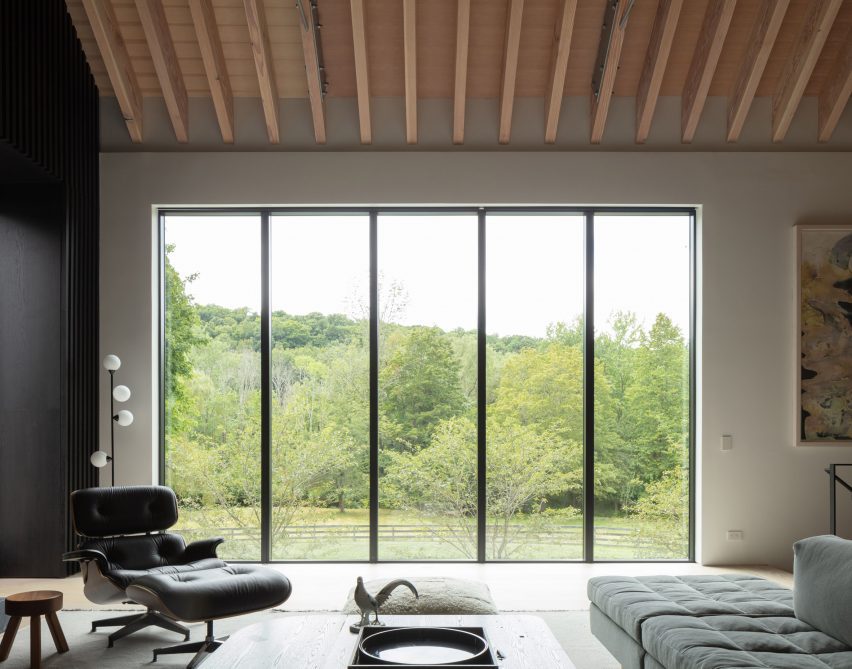 Interior lounge space with tall windows and exposed timber roof structure