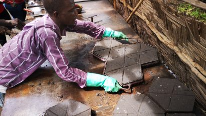 Man laying plastic bricks in Africa