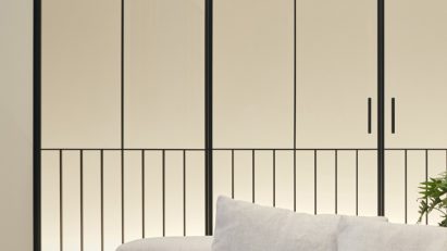 White sofa in front of stripy glass door