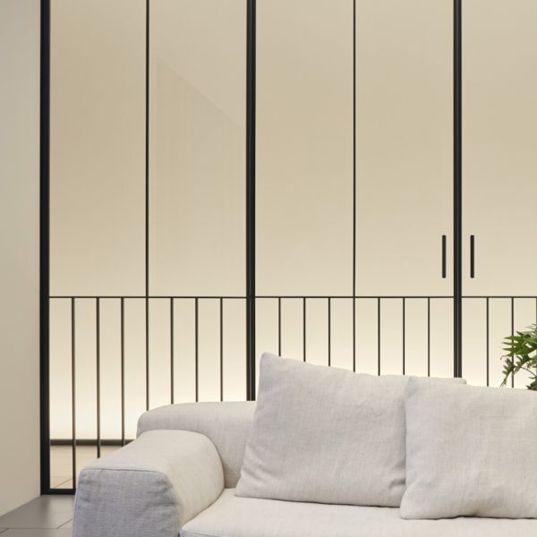 White sofa in front of stripy glass door
