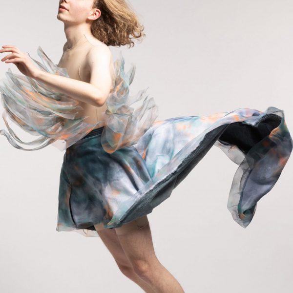 Photograph of person wearing garment that billows out behind them