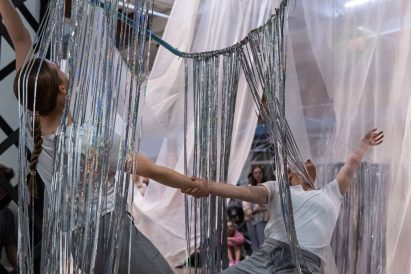 People dancing under an art installation