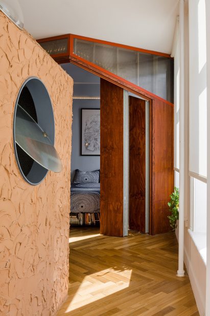 Hand-troweled earthen clay plaster wall in front of plywood doors