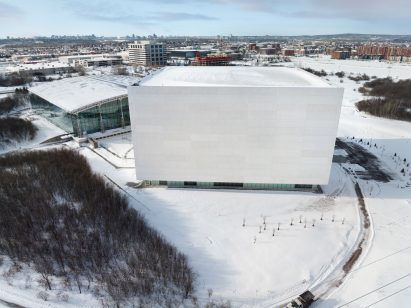 Daytime shot of large concrete cube in the snow