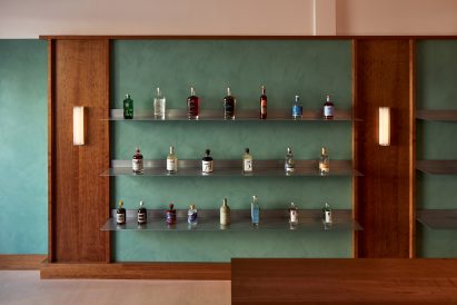 Stainless steel shelves mounted onto dusty green wall