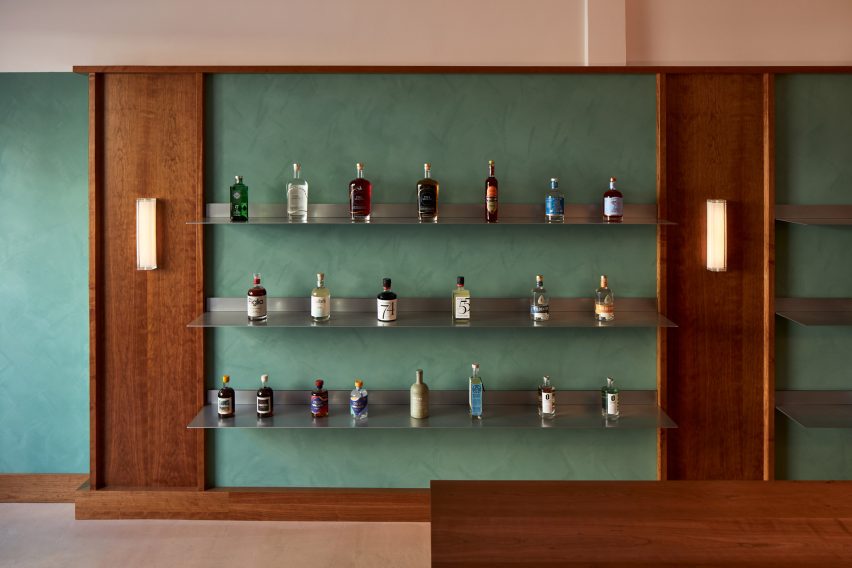 Stainless steel shelves mounted onto dusty green wall