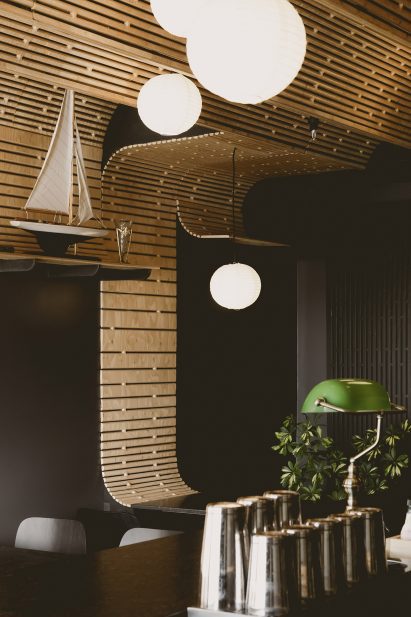 Patterned plywood extends down wall to tabletop