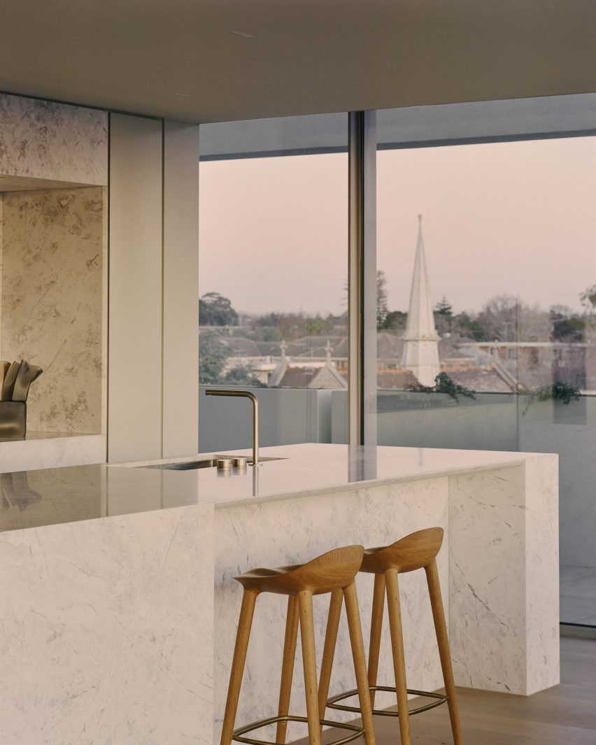 Kitchen in a Perth apartment with marble kitchen island and wooden stools