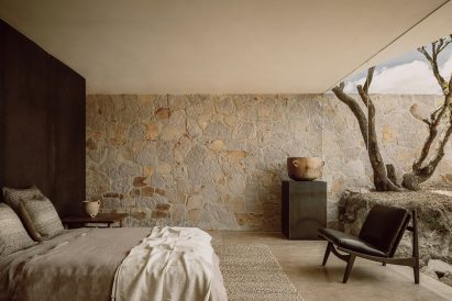 Floor-to-ceiling glass in the bedroom of the stone house in Mexico