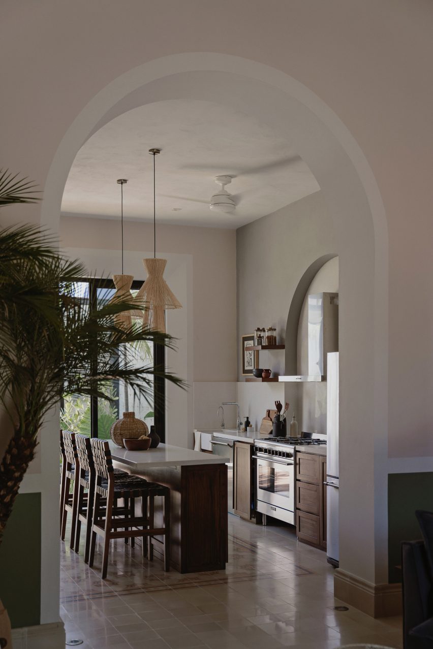 An archway leading to a kitchen with an island and mosaic flooring