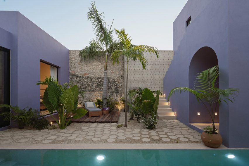 Two purple buildings and a swimming pool at Casa Pulpo by Workshop Architects