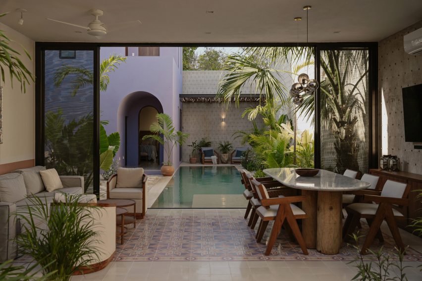 Interior lounge space with mosaic floor tiles and sliding glass doors leading to a swimming pool