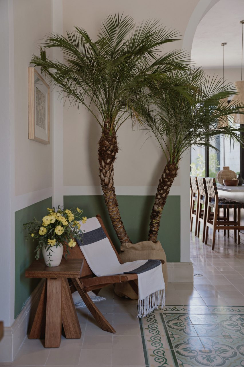 Interior lounge space with a palm tree, chair and mosaic floor tiles