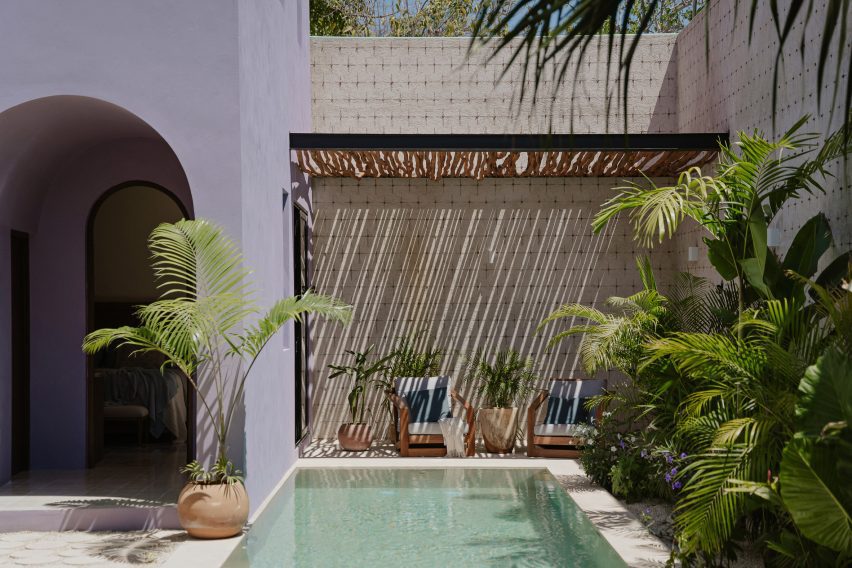 A swimming pool with a terrace and lounge chairs with wood cover overhead