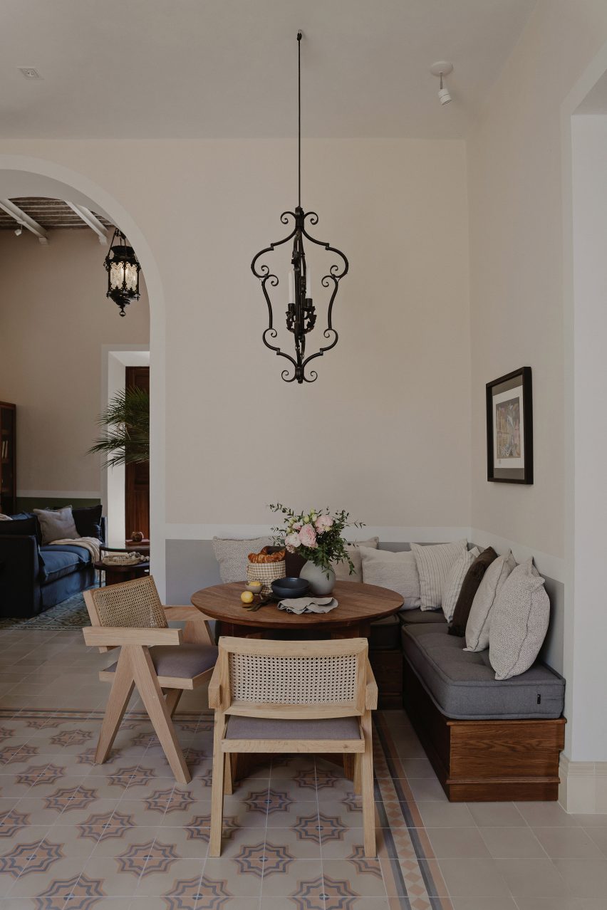 A corner breakfast area in a room with white walls and mosaic floor tiles