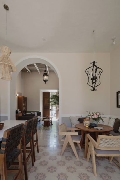 Interior of a kitchen with mosaic floor tiles, a corner breakfast area and archway leading to a living room