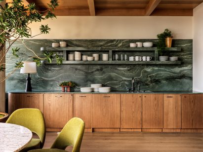 Kitchen featuring green marble countertops, backsplash and shelves