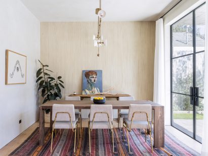 Dining room interior with a striped rug and wooden table and chairs
