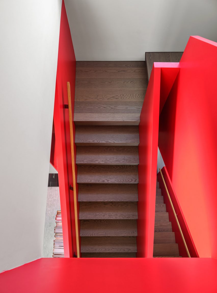 Staircase with dark wood steps and red balustrades
