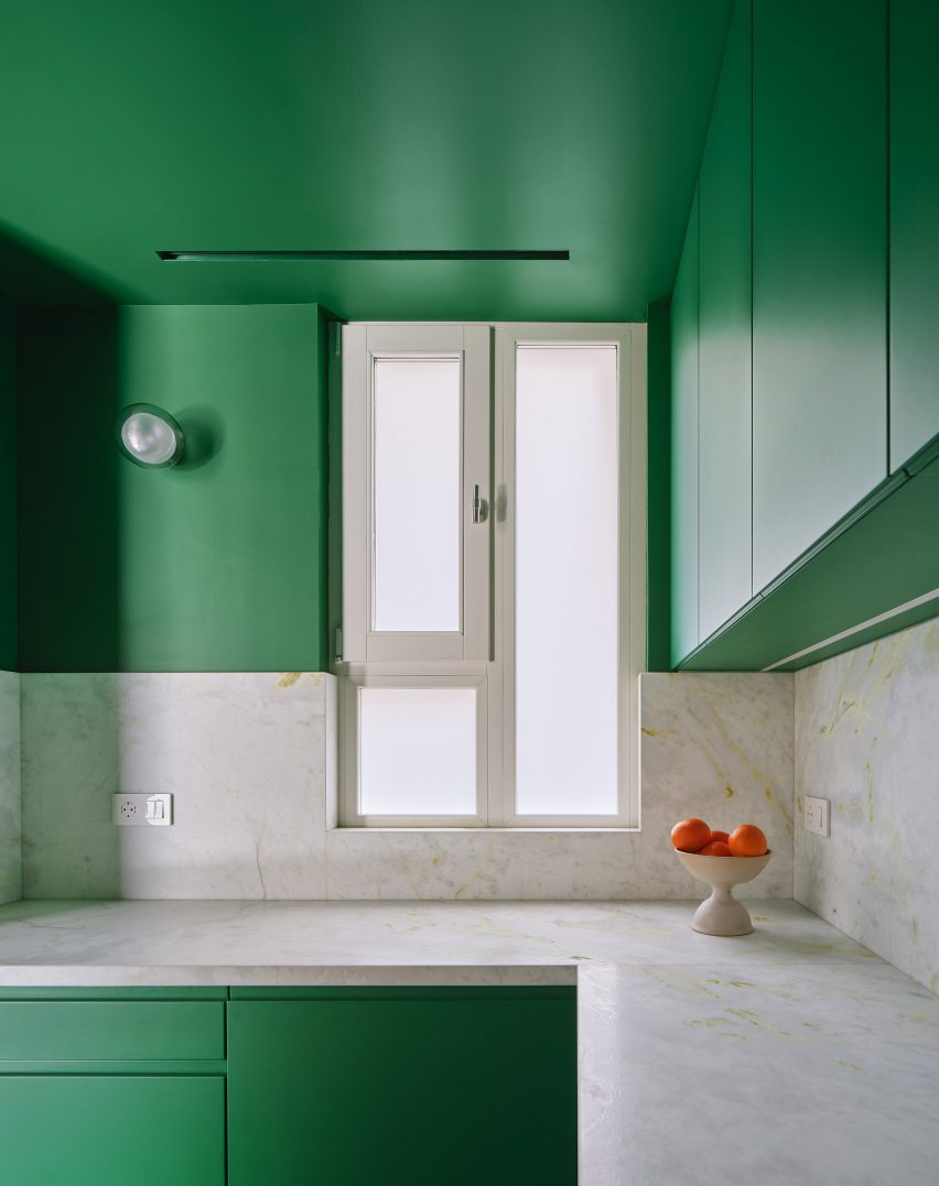 Green kitchen interior of Girona Street apartment in Barcelona, designed by Raúl Sanchez Architects