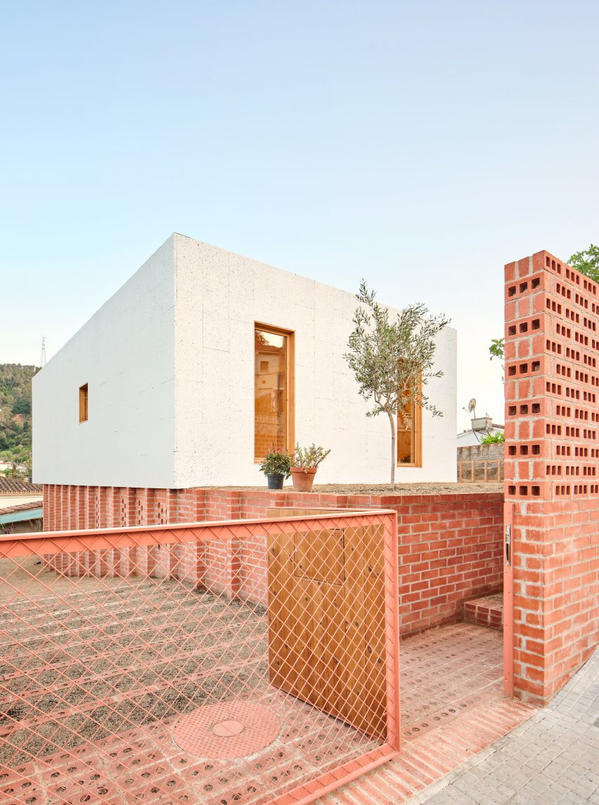 Exterior of House on a Brick Base by Agora Arquitectura