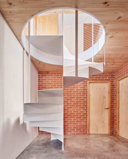 Spiral staircase in Spanish home by Agora Arquitectura
