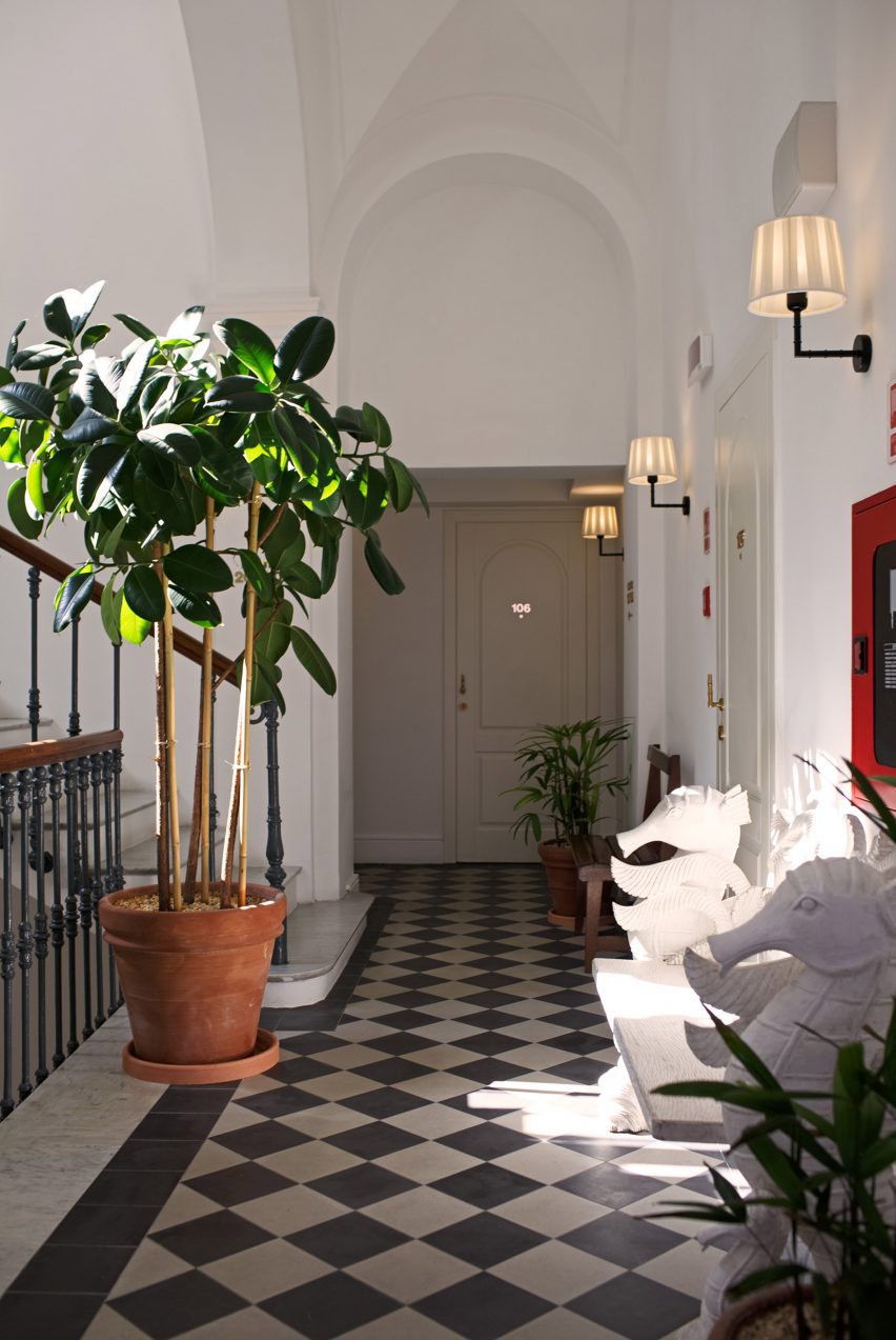 Hallway with checkerboard floor tiles and potted plant