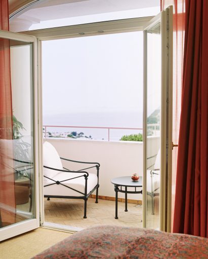 Balcony with chairs overlooking the sea in Il Capri Hotel