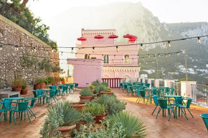 Outdoor terrace with potted plants and bar tables