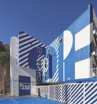 Exterior of the The Alvarado homeless shelter in LA with a graphic blue and white-painted facade
