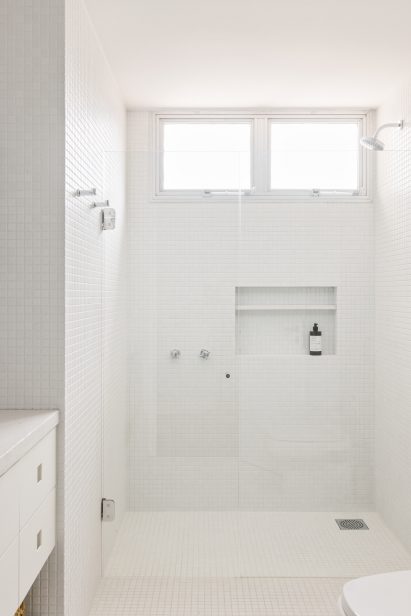 Bathroom lined with white mosaic tiles