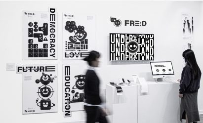 People in a gallery viewing monochromatic posters and media