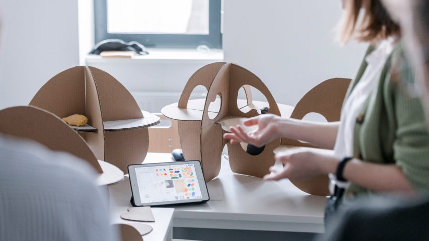 A photograph of a person handling an architectural model.