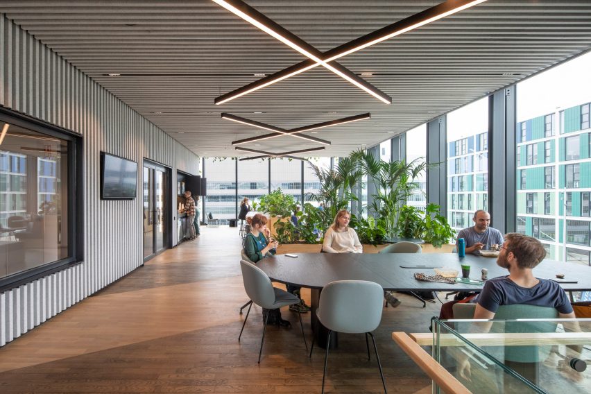 Interior office space with wood flooring, grey walls and large tables