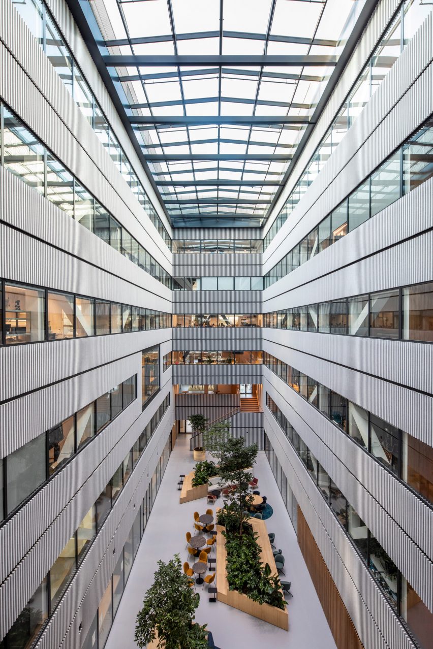 Atrium space at Matrix One by MVRDV with wooden planters and bench seating