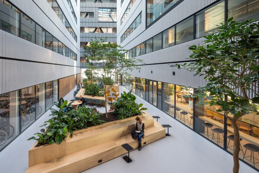 Atrium space at Matrix One by MVRDV with wooden planters and bench seating