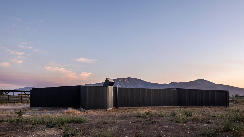 House clad in blackened wood with no visible windows