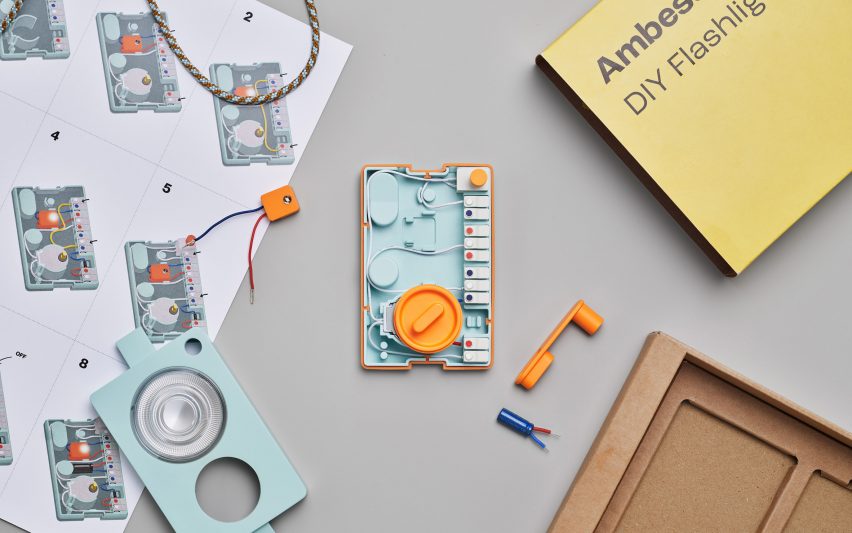 Flatlay photo of an Ambessa Play flashlight disassembled and sitting on a tabletop along with its packaging and instructions