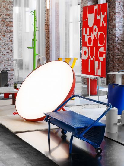 A blue barbecue and a giant circular red mirror on display at the Junkyard Diving exhibition in Milan