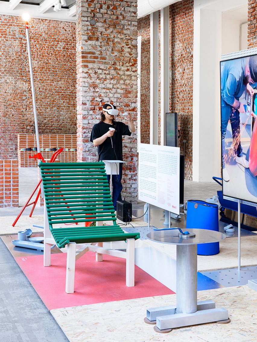 A recliner lounge chair made from a bathroom radiator painted green and laid over a wooden frame sits among other objects in an exhibition of objects made from scrap metal