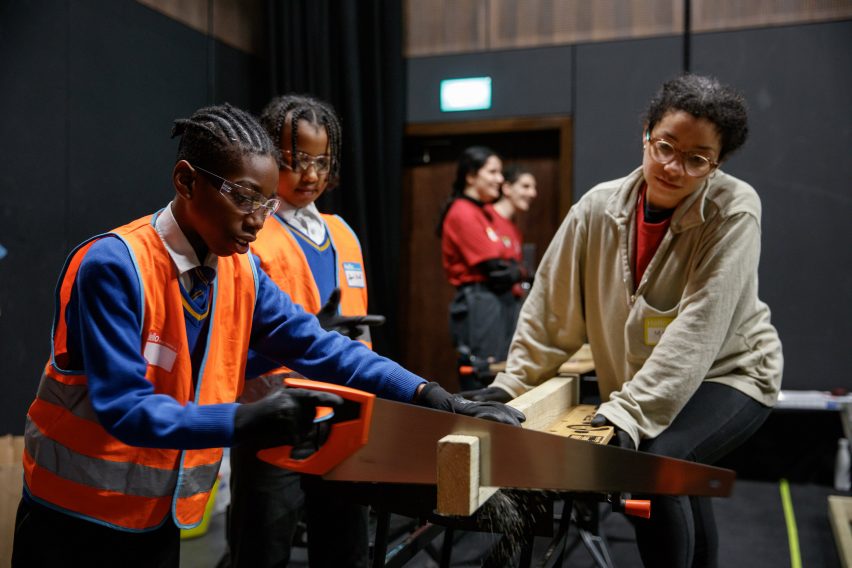 Children and volunteers sawing wood for the Let's Build Brixton House project