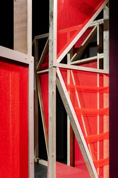 Triangular stages with timber frames and red netting built by school children and Matt+Fiona